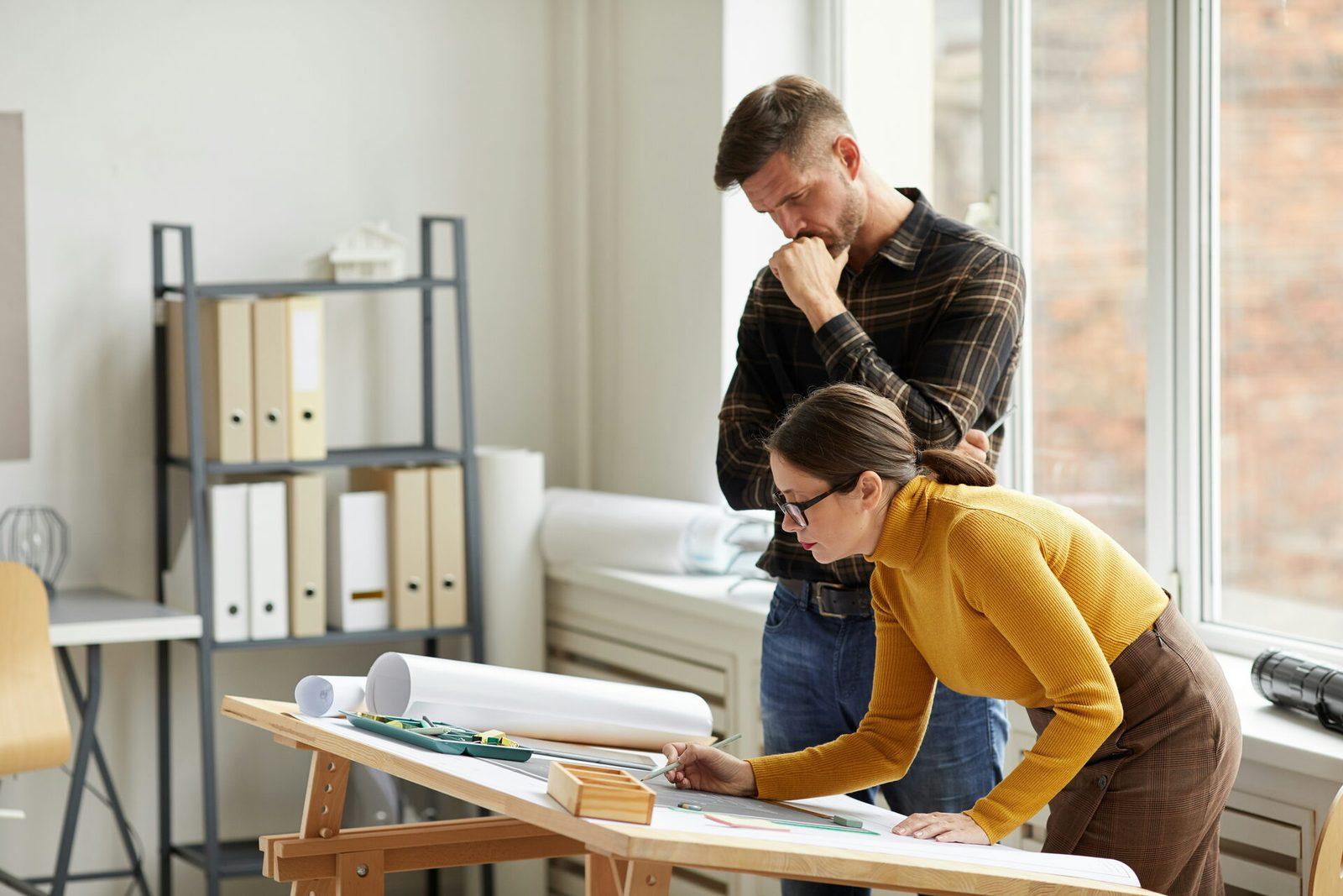 Two architects collaborating over a model